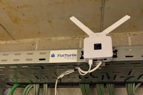 A FlatTurtle-labelled 4G router mounted on a cable tray